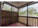 Cozy screened porch with wooden deck and view of surrounding trees at 6289 93Rd N Ter # 4302, Pinellas Park, FL 33782