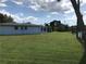 Spacious backyard with green lawn and view of the back of the house at 644 Blue Nw Ln, Port Charlotte, FL 33952