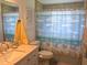 Bathroom with beach-themed shower curtain, white vanity, and beige tile at 644 Blue Nw Ln, Port Charlotte, FL 33952