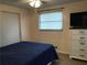 Bedroom featuring blue bedding, white dresser, and window with blinds at 644 Blue Nw Ln, Port Charlotte, FL 33952