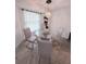 Dining area with a glass-top table, four chairs, and a chandelier at 644 Blue Nw Ln, Port Charlotte, FL 33952