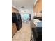 Galley style kitchen with oak cabinets, black appliances, granite countertops, and eat-in area at 644 Blue Nw Ln, Port Charlotte, FL 33952