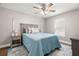 Bedroom featuring a comfortable bed, ceiling fan, and wood floors at 10944 Trelain Way, Hudson, FL 34667