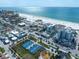 Bright aerial view of a coastal town featuring tennis courts, restaurants, buildings and a gorgeous beach at 15 Avalon St # 704, Clearwater Beach, FL 33767