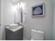 Well-lit bathroom features modern sink, vanity, toilet, and a framed art piece at 15 Avalon St # 704, Clearwater Beach, FL 33767