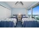 A bedroom with two beds, ceiling fan, ocean view and white closet doors at 15 Avalon St # 704, Clearwater Beach, FL 33767