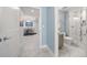 Hallway view of a dining area and bathroom with a large tub and shower, modern vanity and commode at 15 Avalon St # 704, Clearwater Beach, FL 33767