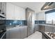 Modern kitchen with stainless steel appliances, white cabinetry, and blue subway tile backsplash at 15 Avalon St # 704, Clearwater Beach, FL 33767