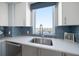 Well-lit kitchen featuring modern countertops, a stainless steel sink, and stylish blue backsplash at 15 Avalon St # 704, Clearwater Beach, FL 33767