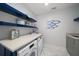 Laundry room with Miele washer/dryer, shelving with coastal décor, and marble floors at 15 Avalon St # 704, Clearwater Beach, FL 33767