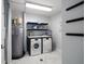 Laundry room with modern washer, dryer, bright lighting, shelves and coastal decor at 15 Avalon St # 704, Clearwater Beach, FL 33767