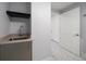 Laundry room with a sink and modern faucet and grey cabinetry at 15 Avalon St # 704, Clearwater Beach, FL 33767