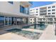Outdoor pool area features a hot tub and pool with building in background at 15 Avalon St # 704, Clearwater Beach, FL 33767