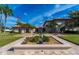 Clubhouse exterior with a landscaped garden, palm trees, and an American flag at 19029 Us Highway 19 # 25D, Clearwater, FL 33764