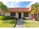 Charming home featuring a red tile roof, lush landscaping, and a well-maintained lawn at 19029 Us Highway 19 # 25D, Clearwater, FL 33764