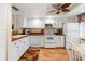 Kitchen with white cabinets, copper countertops, and white appliances at 19029 Us Highway 19 # 25D, Clearwater, FL 33764