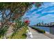 Waterfront community with a bench, lush trees, and pink flowers along the pathway at 19029 Us Highway 19 # 25D, Clearwater, FL 33764