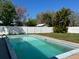 Sparkling swimming pool surrounded by a white fence and green landscaping, creating a private backyard oasis at 1948 Jeffords St, Clearwater, FL 33764