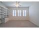 Bright bedroom with a ceiling fan, built in shelving, and three windows at 2463 Kensington Greens Dr, Sun City Center, FL 33573