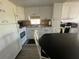 Kitchen with white cabinets, appliances, sink, and adjacent dining area at 27466 Us Highway 19 N # 16, Clearwater, FL 33761