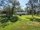 Spacious backyard showcasing home, pool, and lush green space at 3010 Maple Trce, Tarpon Springs, FL 34688