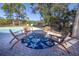 Relaxing poolside patio with wooden chairs and a nautical rug at 3010 Maple Trce, Tarpon Springs, FL 34688