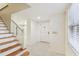 Entryway with stairs, terrazzo floor, front door, and view to dining room at 3322 W Dorchester St, Tampa, FL 33611