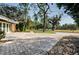 Driveway and walkway of a house with trees and grass at 502 N Herchel Dr, Temple Terrace, FL 33617