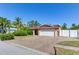 Charming home with a white garage door, paver driveway, and fenced yard at 5875 Bay Pines Lakes Blvd, St Petersburg, FL 33708