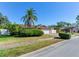 Exterior view of a house with palm trees, shrubs, and a white fence at 5875 Bay Pines Lakes Blvd, St Petersburg, FL 33708