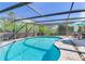 Spacious pool area with screen enclosure, patio furniture, and lush backyard at 5875 Bay Pines Lakes Blvd, St Petersburg, FL 33708