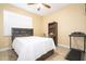 Bedroom with dark wood bedframe, white bedding, ceiling fan, and treadmill at 810 W Whatley Pl, Tampa, FL 33604