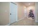 Hallway with decorated Christmas tree, white doors, and tiled flooring at 810 W Whatley Pl, Tampa, FL 33604