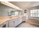 Large bathroom featuring a double vanity sink, garden tub, and bright lighting at 8620 Brookway Cir, Tampa, FL 33635