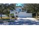 A charming two-story home featuring a three-car garage, lush front yard, and white picket fence at 8620 Brookway Cir, Tampa, FL 33635