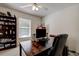 Bright office space with a ceiling fan, window, and dark wood desk and bookshelf at 8620 Brookway Cir, Tampa, FL 33635
