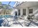Relaxing patio area with outdoor seating and view of screened pool enclosure at 8620 Brookway Cir, Tampa, FL 33635