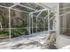 Screened pool enclosure featuring outdoor seating and serene backyard views at 8620 Brookway Cir, Tampa, FL 33635