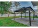 Covered patio in backyard with white fence and green lawn at 9112 Bell Rock Pl, Land O Lakes, FL 34638