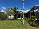 Lush green backyard with palm trees and a screened enclosure at 914 Sago Palm Way, Apollo Beach, FL 33572