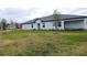 Back view of a single-story home with a grassy backyard at 16851 Forge Surf St, Land O Lakes, FL 34638