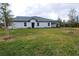 View of the backyard with green grass and trees at 16851 Forge Surf St, Land O Lakes, FL 34638