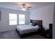 Spacious bedroom with large windows, ceiling fan, and wooden bedframe at 16851 Forge Surf St, Land O Lakes, FL 34638