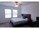 Spacious bedroom with large windows, ceiling fan, and a wooden bedframe at 16851 Forge Surf St, Land O Lakes, FL 34638