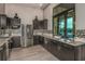 Stylish kitchen with dark cabinets, stainless steel appliances, and granite countertops at 20375 Symphony Pl, Venice, FL 34293