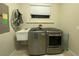 Bright laundry room with washer, dryer and utility sink at 3020 Sheppards Crook Ct, Holiday, FL 34691