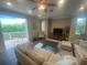 Relaxing living room with large windows, access to a balcony, and ample seating at 3020 Sheppards Crook Ct, Holiday, FL 34691