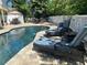 Relaxing pool area with lounge chairs and patio furniture at 3020 Sheppards Crook Ct, Holiday, FL 34691
