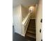 Modern staircase with dark wood steps and white railing at 3020 Sheppards Crook Ct, Holiday, FL 34691