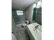 Clean bathroom featuring a shower/tub combo, single vanity, and marble-look tile flooring at 3349 Overland Dr, Holiday, FL 34691